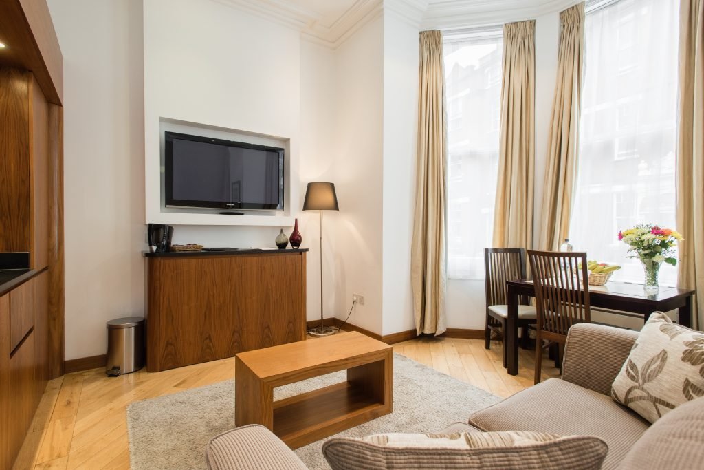Deluxe Studio living area with sofa, TV and dining table