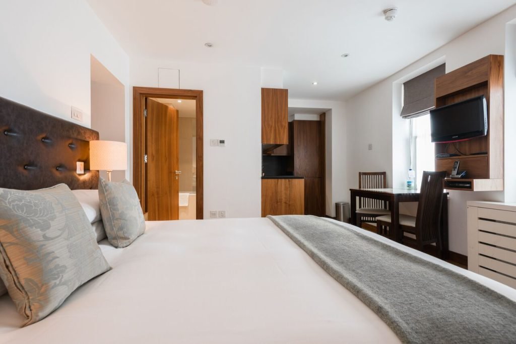 Standard Studio double bed with the dining table and kitchen behind