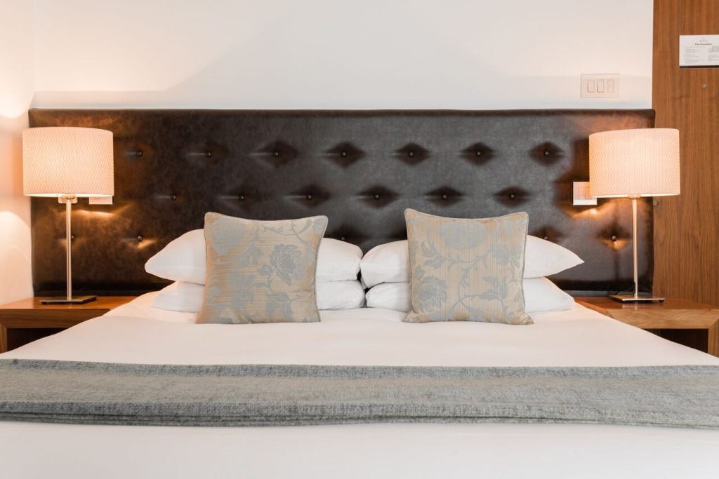 Standard Studio double bed with a padded headboard and bedside lamps